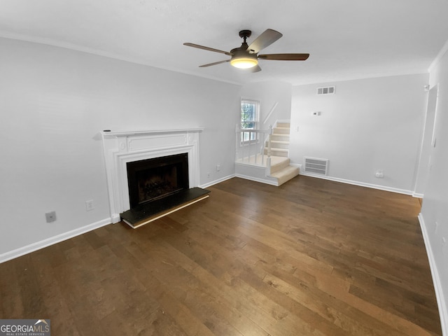 unfurnished living room with ceiling fan, dark wood-type flooring, and ornamental molding