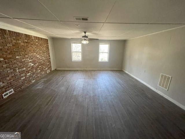 spare room featuring ceiling fan, brick wall, and dark hardwood / wood-style floors