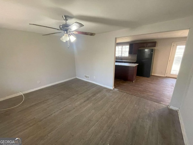 unfurnished living room with ceiling fan, dark hardwood / wood-style flooring, and sink