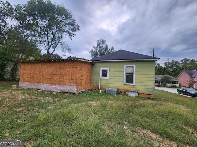 view of home's exterior with cooling unit and a lawn