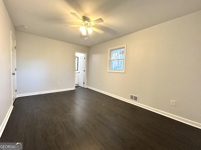 empty room with ceiling fan and dark hardwood / wood-style flooring