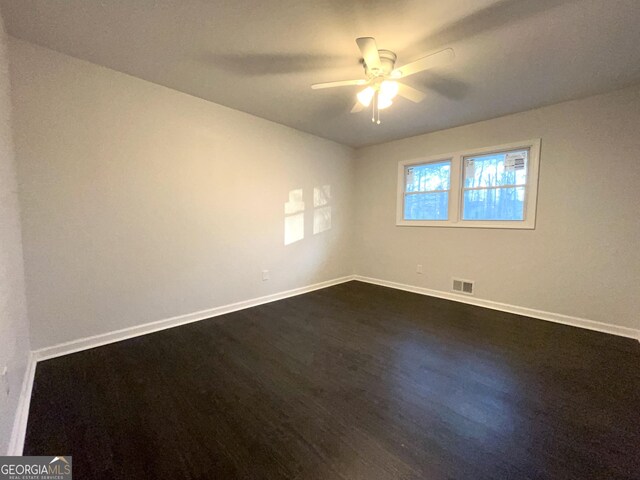 unfurnished room with ceiling fan and dark hardwood / wood-style flooring