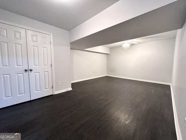 basement with ceiling fan and dark hardwood / wood-style floors