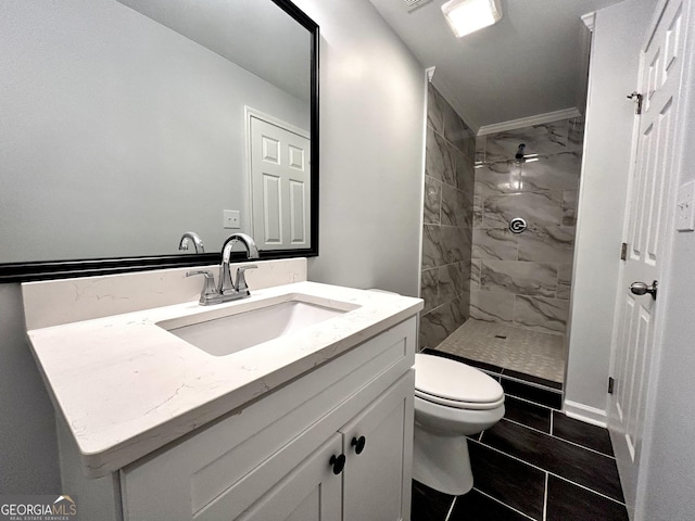 bathroom with toilet, vanity, and a tile shower