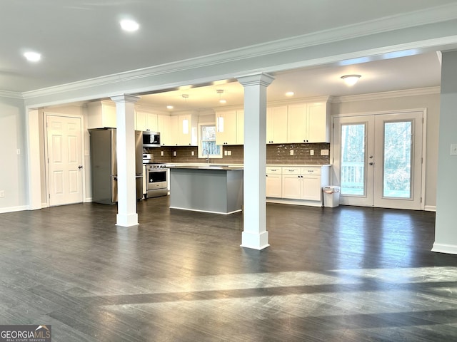 unfurnished living room with sink, ornamental molding, and french doors