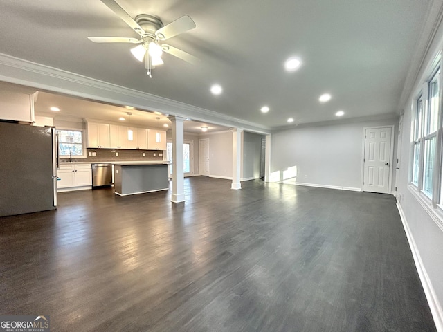 unfurnished living room featuring dark wood-type flooring, ceiling fan, crown molding, and sink