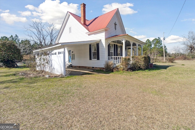 view of home's exterior with a yard, a garage, and a porch