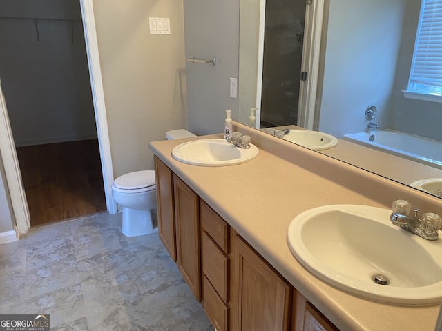 bathroom featuring toilet, a bath, and vanity