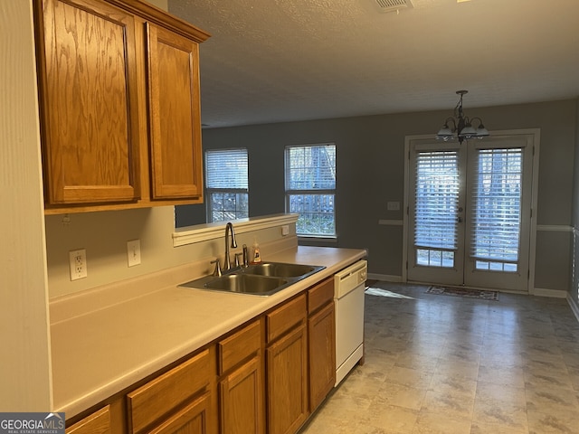 kitchen with a wealth of natural light, white dishwasher, sink, and an inviting chandelier