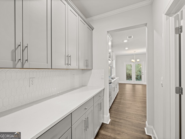 42 Parkview Dr, Dallas, GA 30157 - bar with dark hardwood / wood-style flooring, decorative backsplash, a notable chandelier, gray cabinetry, and crown molding