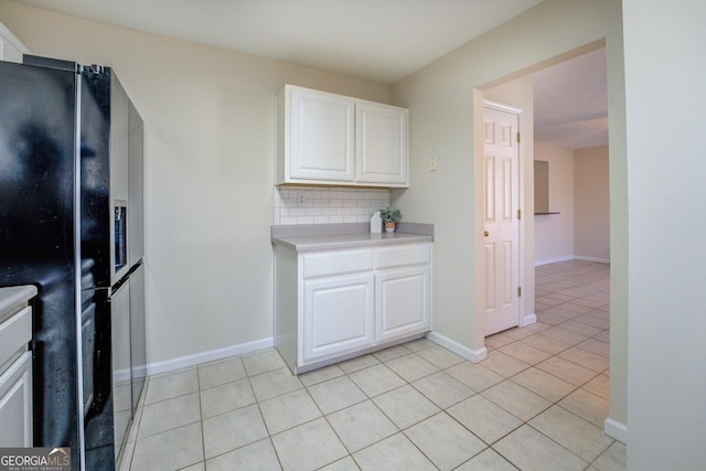 kitchen with light tile patterned floors, white cabinets, tasteful backsplash, and black fridge with ice dispenser