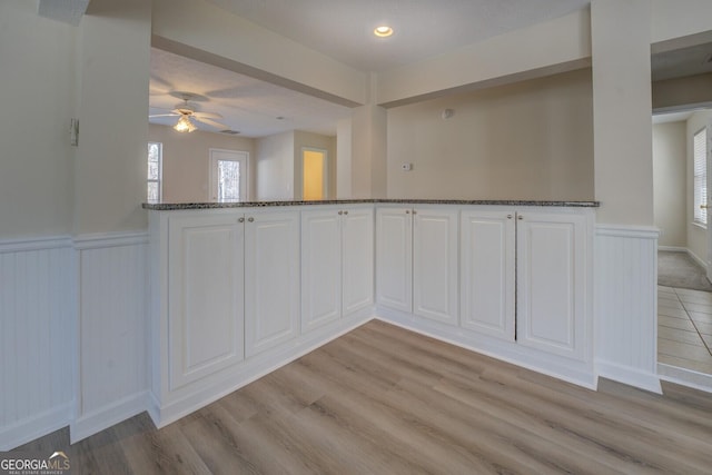 unfurnished dining area with ceiling fan and light hardwood / wood-style flooring