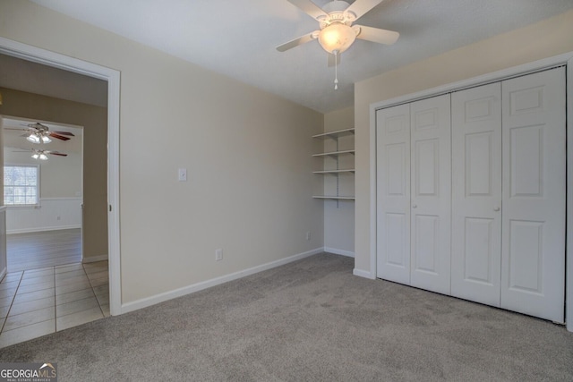 unfurnished bedroom with ceiling fan, light carpet, and a closet