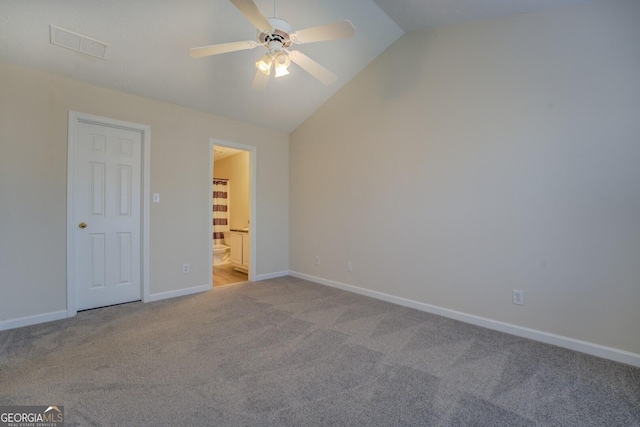 unfurnished bedroom with vaulted ceiling, ceiling fan, ensuite bathroom, and light carpet