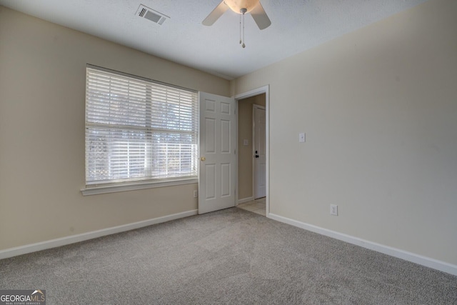 empty room featuring light carpet and ceiling fan