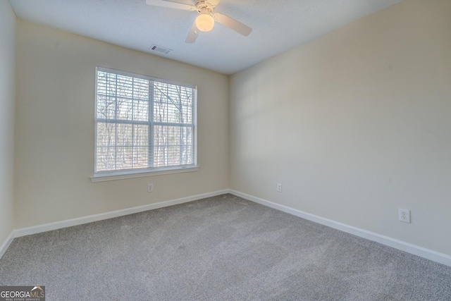 spare room with ceiling fan and carpet