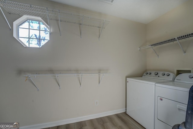 washroom featuring light wood-type flooring and washer and clothes dryer