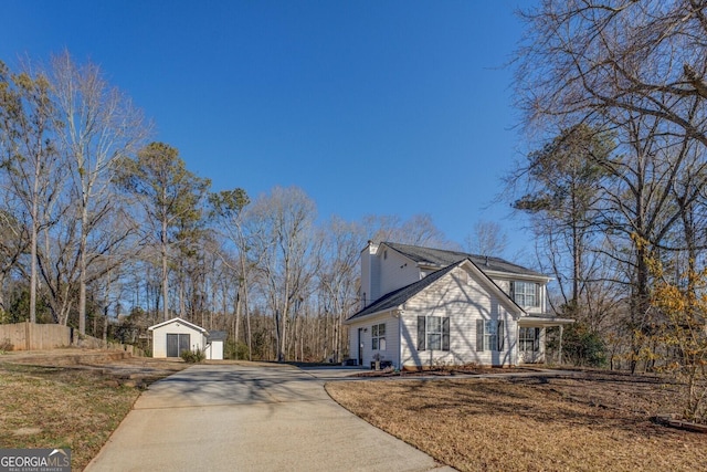 view of side of home featuring a lawn, an outdoor structure, and a garage