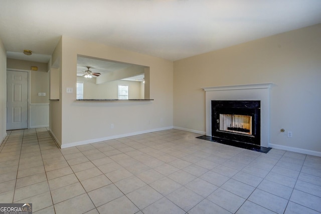 unfurnished living room featuring ceiling fan and light tile patterned floors