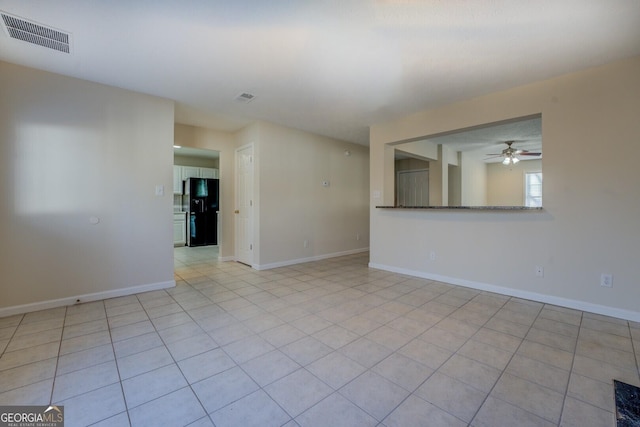 tiled spare room with ceiling fan