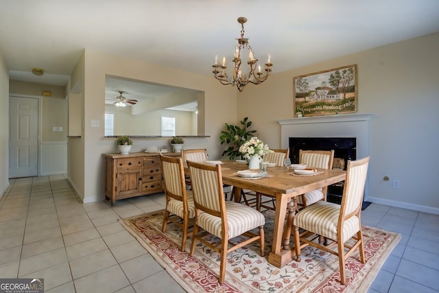 dining room featuring light tile patterned floors and ceiling fan with notable chandelier