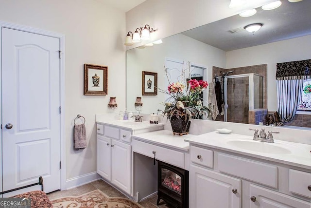 bathroom with an enclosed shower, vanity, and tile patterned floors