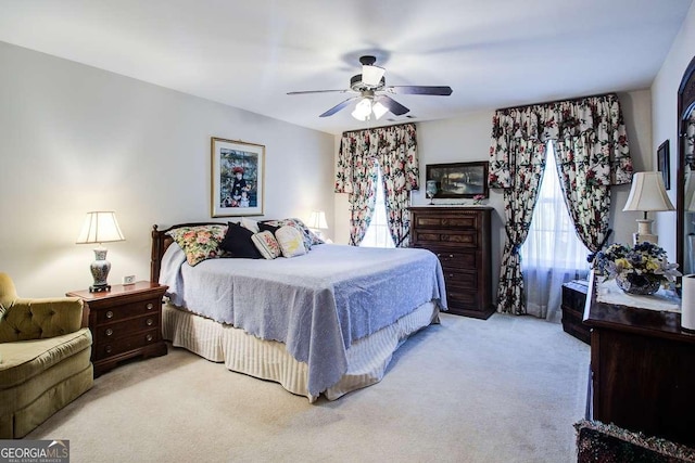 carpeted bedroom with ceiling fan and multiple windows