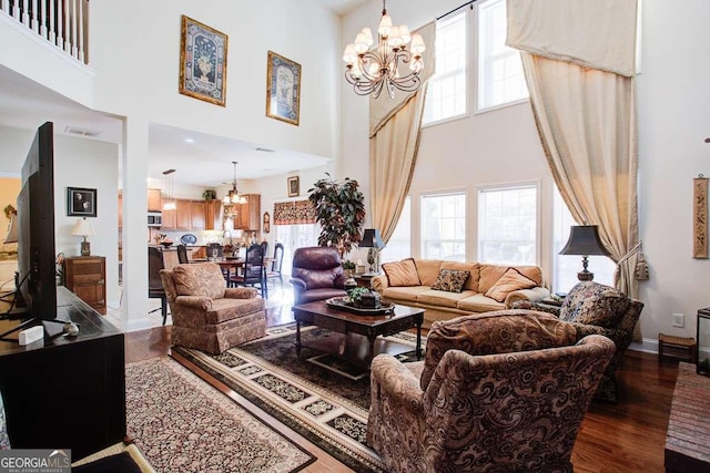 living room featuring an inviting chandelier, dark hardwood / wood-style flooring, and a high ceiling