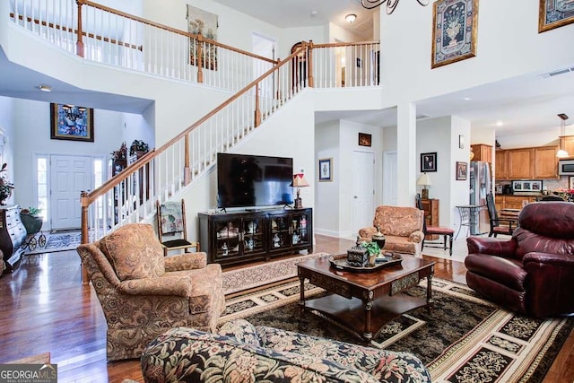 living room with a high ceiling and dark hardwood / wood-style flooring