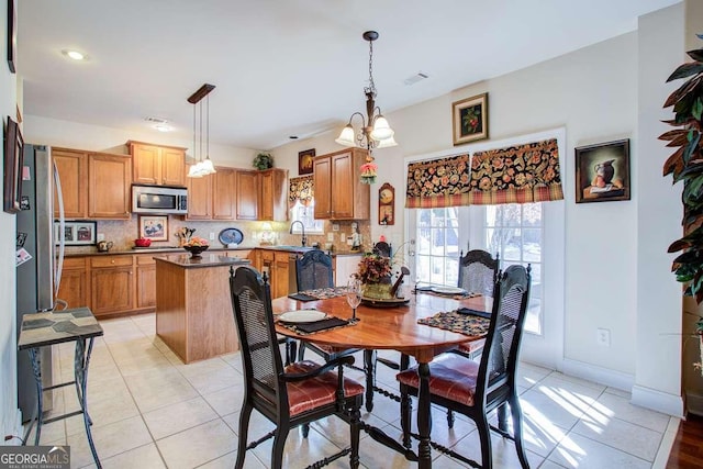 tiled dining area featuring an inviting chandelier