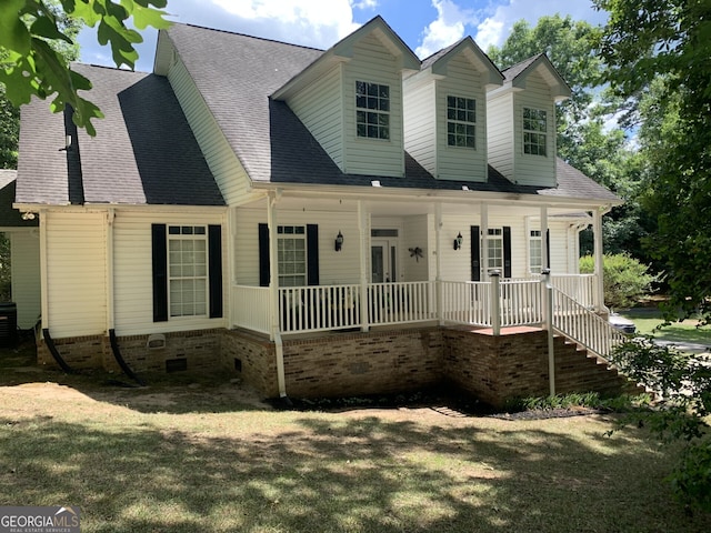 new england style home featuring a front yard, a porch, and french doors