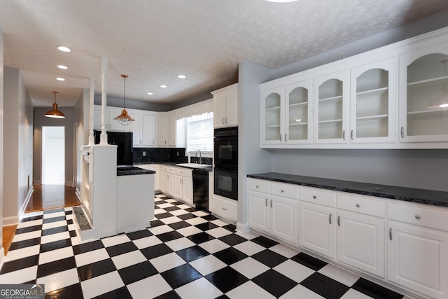 kitchen with backsplash, black appliances, sink, hanging light fixtures, and white cabinets