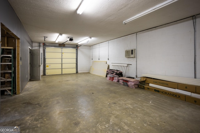 garage with a garage door opener and a wall mounted air conditioner