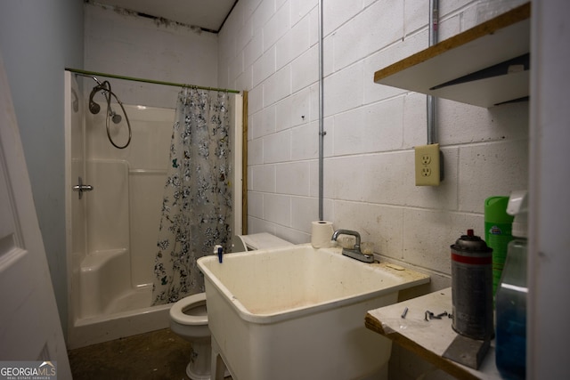 bathroom featuring toilet, a shower with shower curtain, and sink