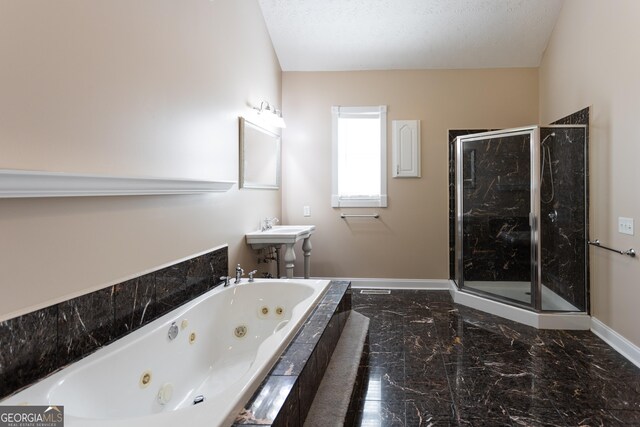 bathroom featuring sink, independent shower and bath, and a textured ceiling