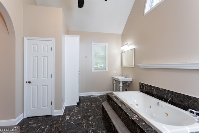 bathroom featuring tiled bath, vaulted ceiling, sink, and ceiling fan