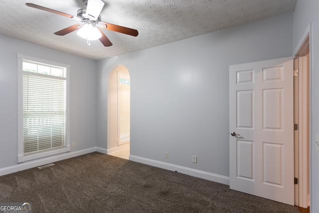 carpeted spare room with a textured ceiling and ceiling fan