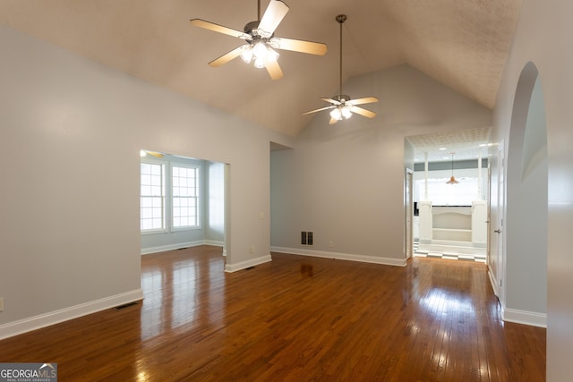 empty room with ceiling fan, dark hardwood / wood-style flooring, and vaulted ceiling