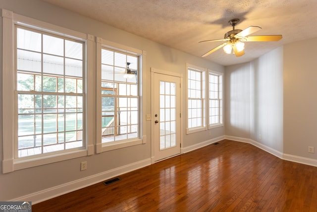 doorway to outside featuring ceiling fan, a textured ceiling, and dark hardwood / wood-style floors