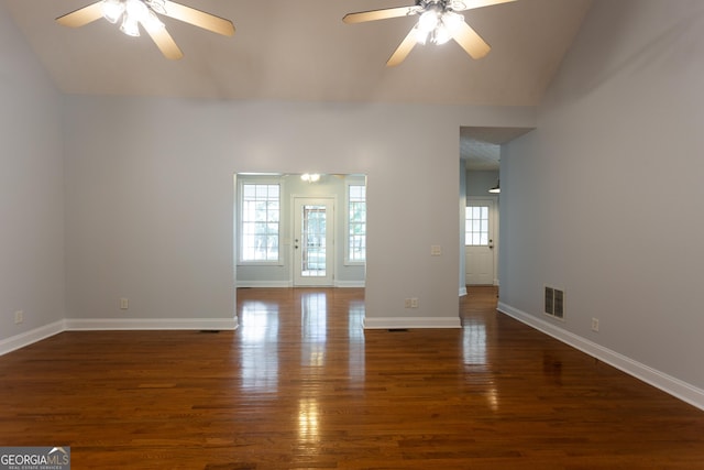 empty room with ceiling fan, plenty of natural light, and dark hardwood / wood-style flooring