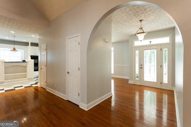 entryway with lofted ceiling, a healthy amount of sunlight, and hardwood / wood-style flooring