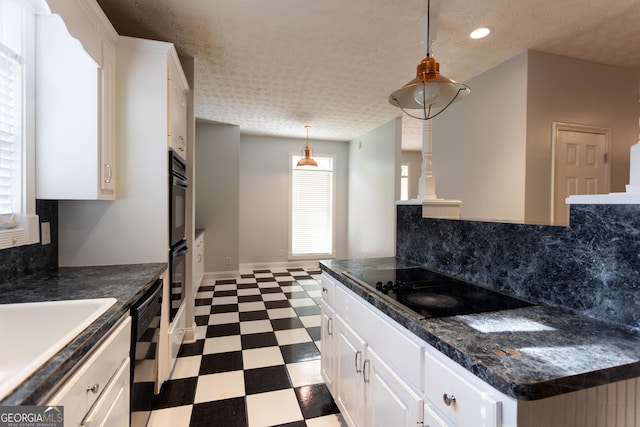 kitchen with decorative light fixtures, white cabinets, and black appliances