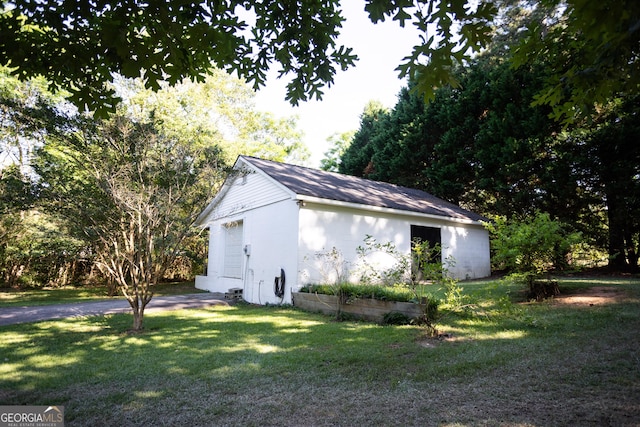 view of side of home featuring an outbuilding and a lawn