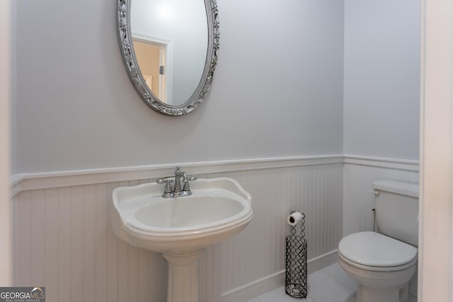 bathroom with toilet, tile patterned floors, and sink