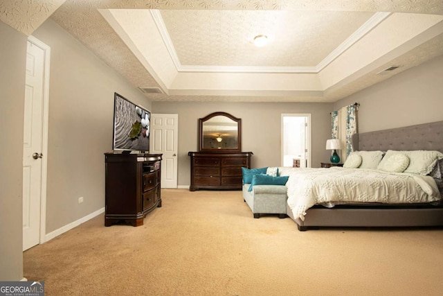 carpeted bedroom with a textured ceiling, ornamental molding, and a tray ceiling