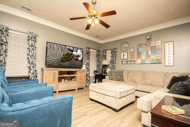 living room with a textured ceiling, ceiling fan, ornamental molding, and light hardwood / wood-style flooring