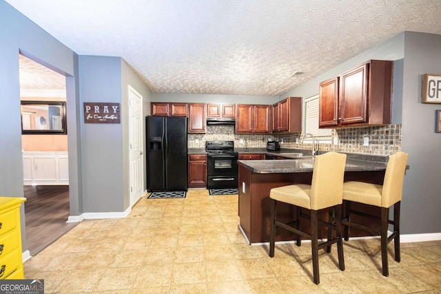 kitchen featuring decorative backsplash, black appliances, kitchen peninsula, and a breakfast bar area