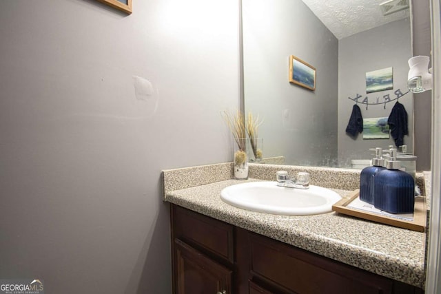 bathroom with a textured ceiling and vanity