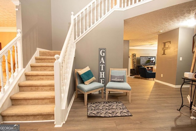 stairway featuring hardwood / wood-style flooring and ornamental molding