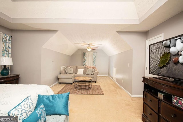 bedroom featuring ceiling fan, a textured ceiling, light carpet, and lofted ceiling